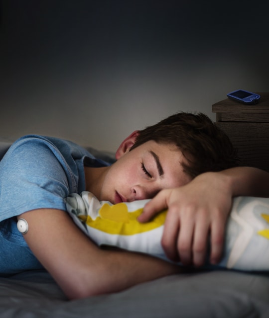 Child sleeping wearing a FreeStyle Libre sensor on arm